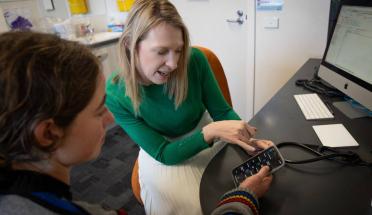 A doctor shows a patient the My Health Record app in her office.